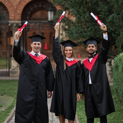 International graduates from celebrating diplomas in graduation robes.